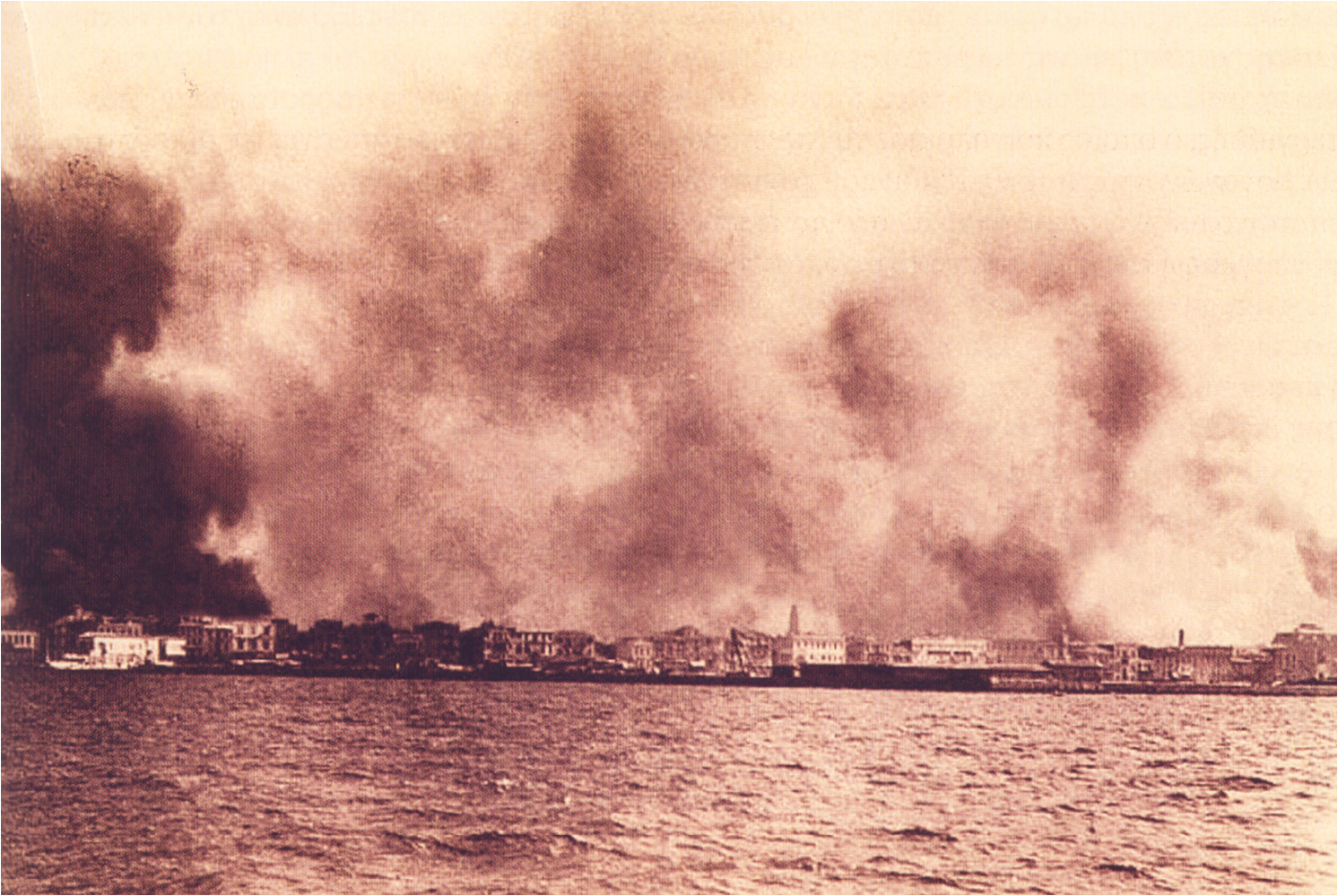 Coastal city waterfront with massive smoke plumes