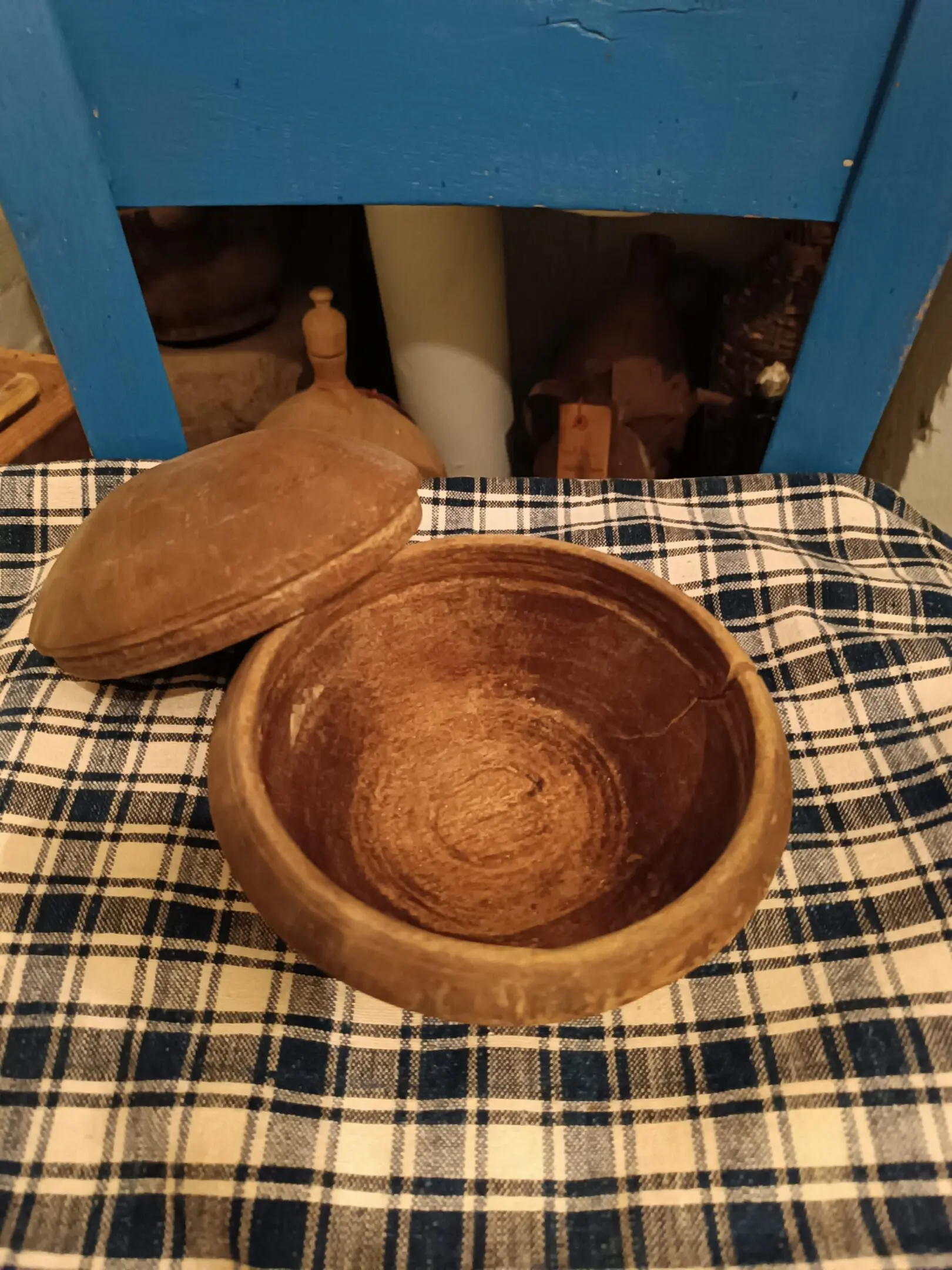 Rustic wooden bowl with lid on plaid cloth