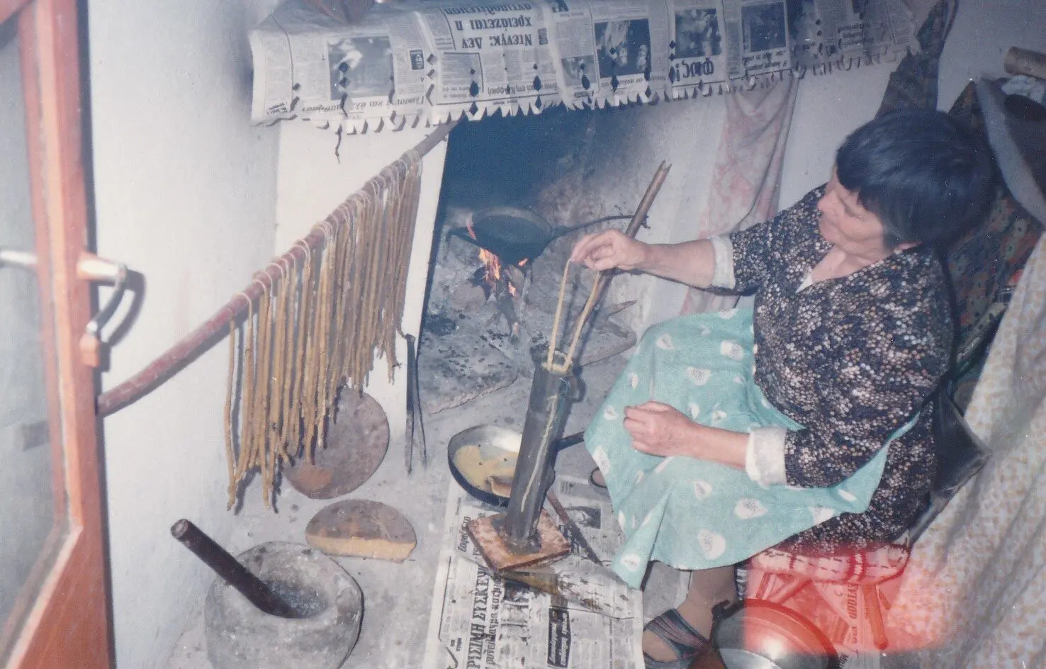 Woman making homemade noodles by fireplace