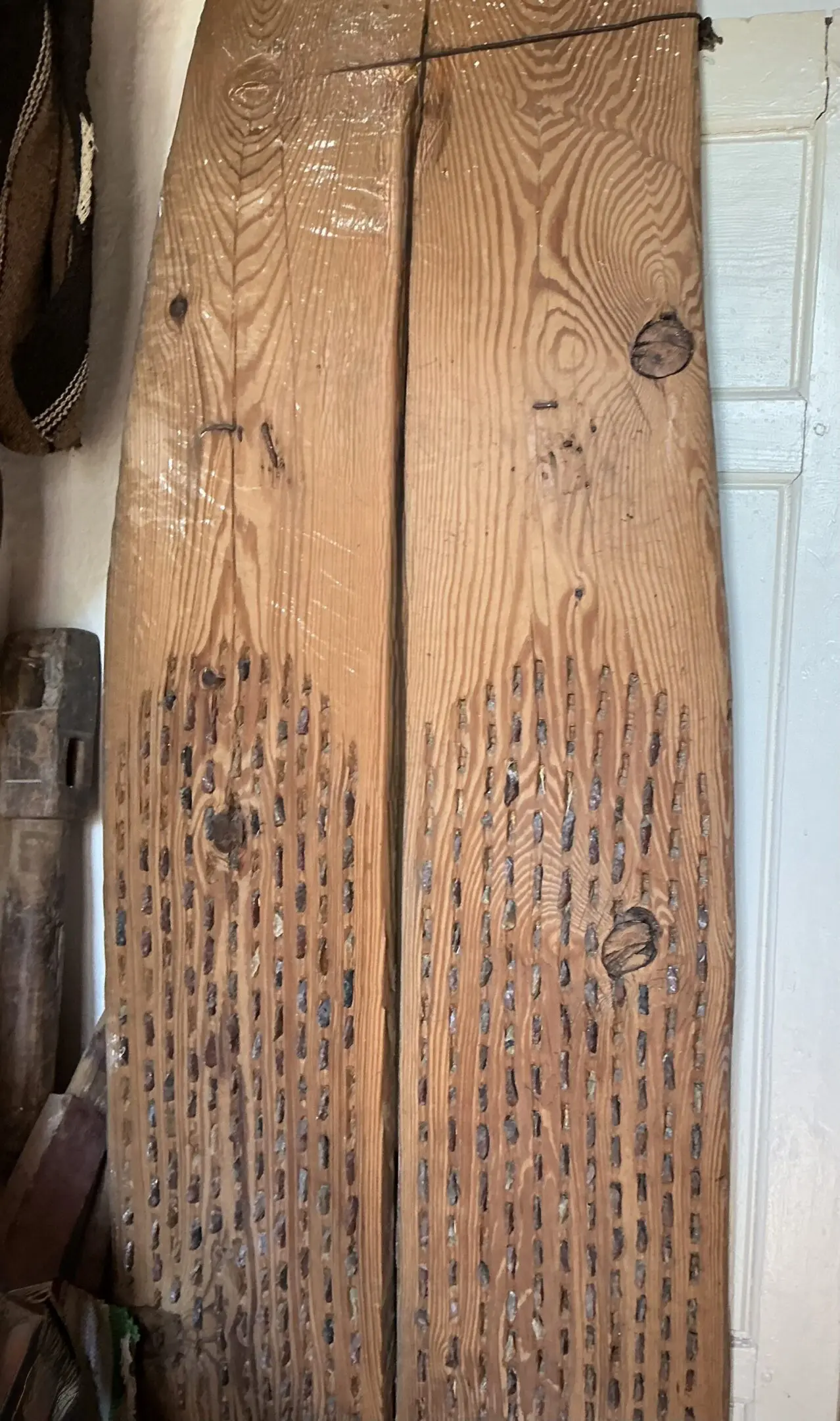 Two carved wooden planks leaning against wall