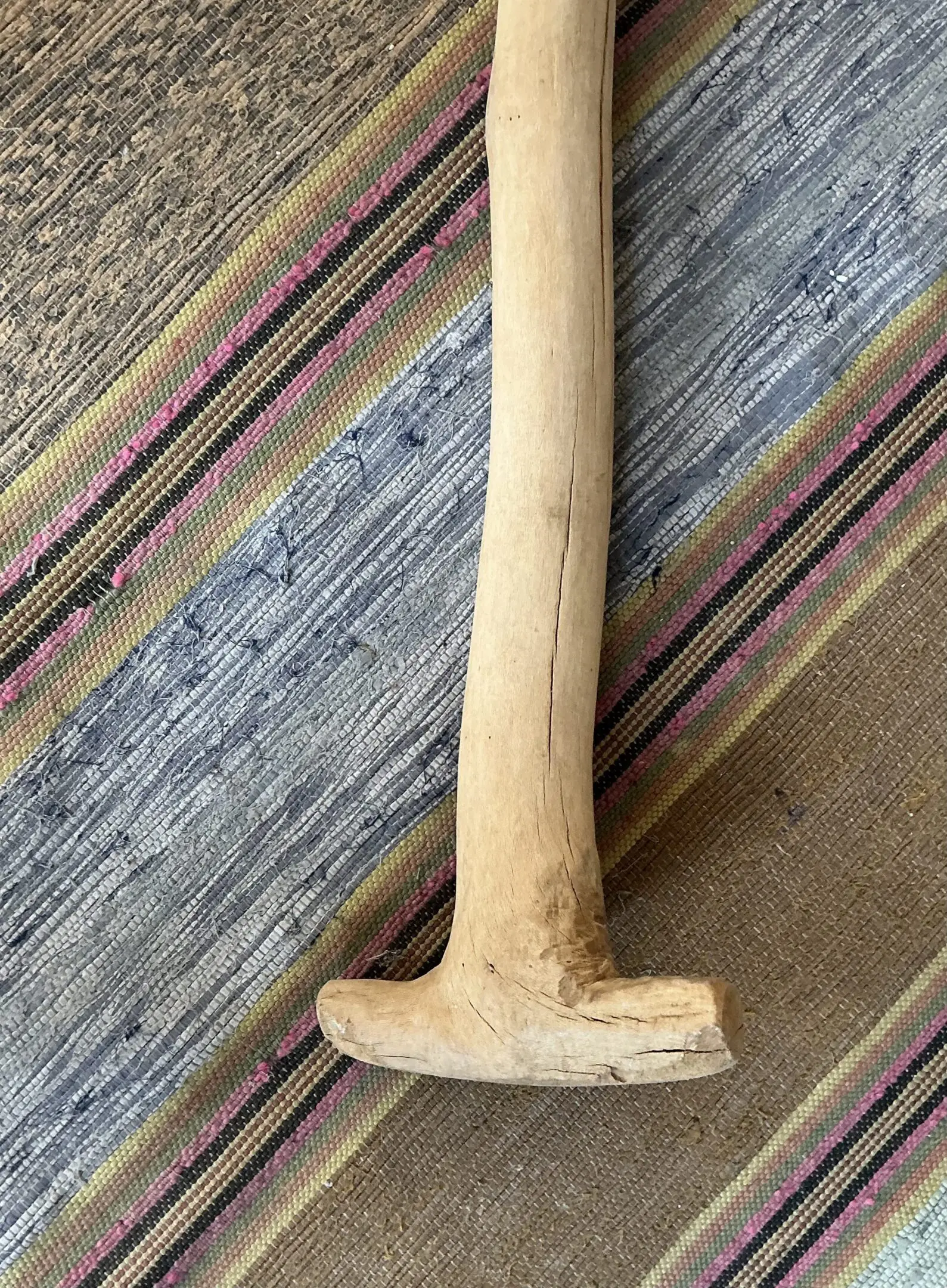 Wooden mallet on striped woven rug