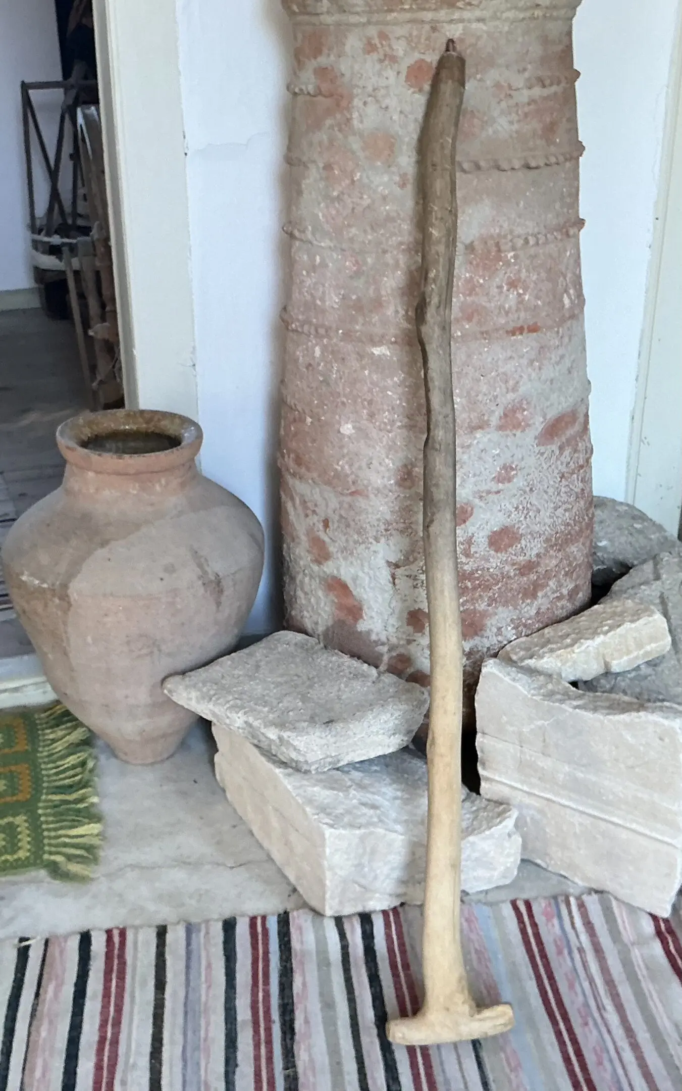 Antique wooden mallet leaning beside clay vessels