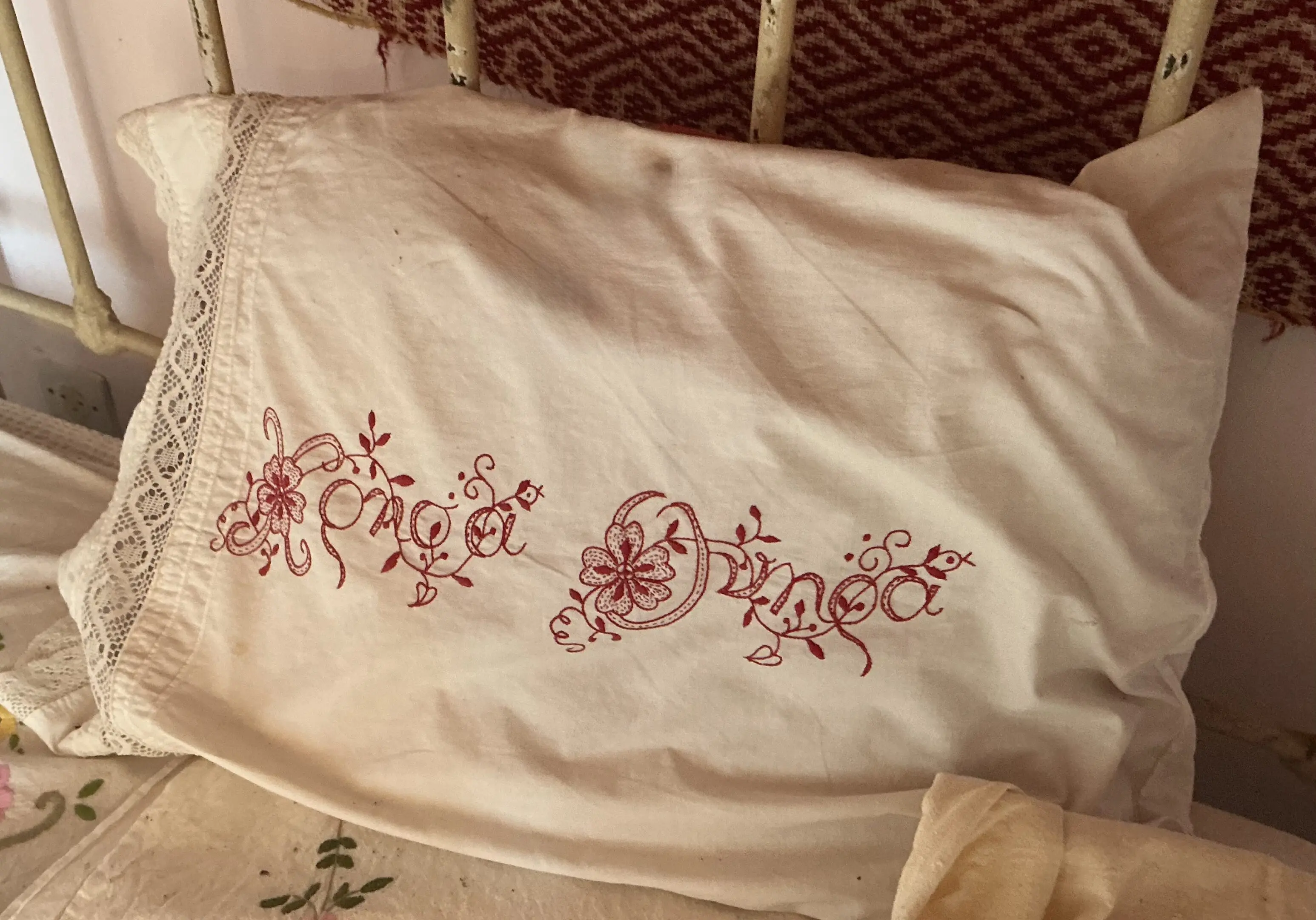 Lace trimmed vintage pillowcase with red embroidery