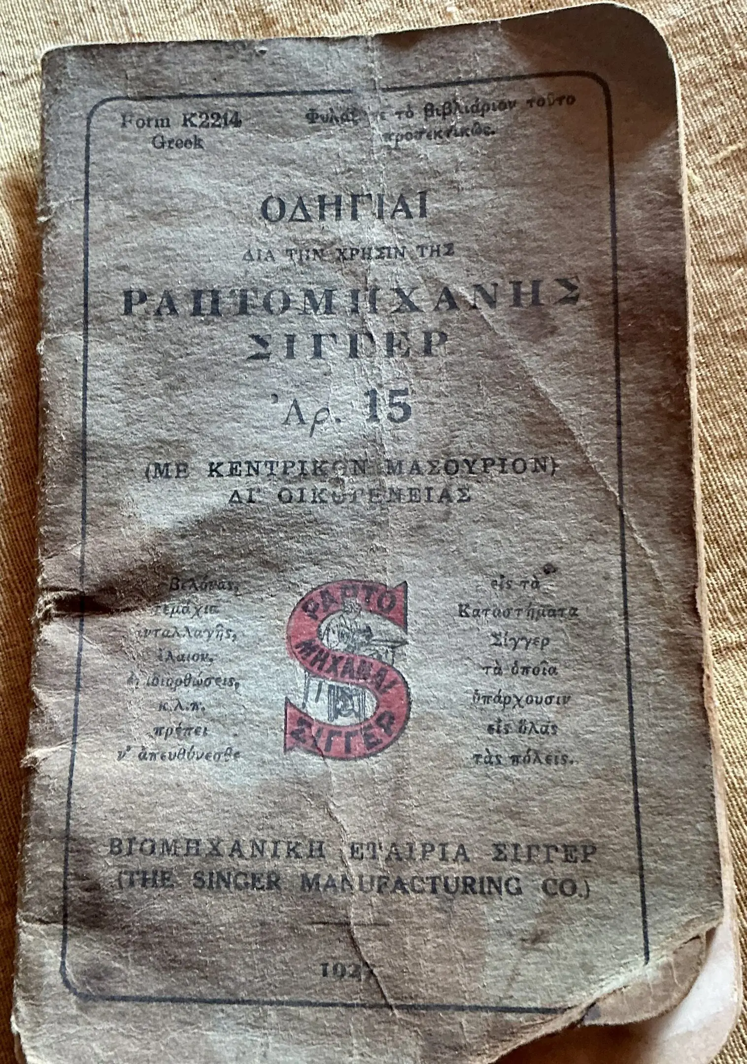 Worn Greek Singer sewing machine manual cover